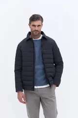 Campera puffer de color azul marino con diseño de líneas horizontales, cuello camisero y cierre frontal oculto. Presenta un calce regular y estructura liviana, ideal para uso urbano.