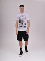 Remera blanca de algodón con cuello redondo y estampado frontal de la Estatua de la Libertad en blanco y negro, con la inscripción "Liberty Evolution Music New York".