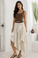 Falda midi asimétrica de algodón en color beige, con diseño de volados en cascada e incluye cinturón trenzado marrón.