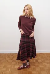 Falda midi de corte irregular con diseño a cuadros en tonos marrones, negros y beige. Presenta una silueta acampanada con caída fluida.