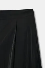 Bermuda de tiro medio color negro con pliegues delanteros y bolsillos laterales ocultos en costura. Cuenta con cierre delantero con cremallera, botón y ganchos metálicos.