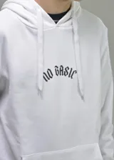 Hoodie blanco con capucha y bolsillo tipo canguro. Presenta un estampado en la espalda con la inscripción 'No Basic' en fuente gótica y debajo el texto 'made in Uruguay'.