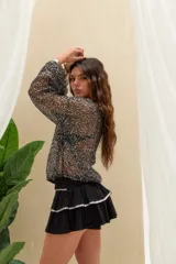 Short pollera negro de tiro alto con diseño de volados escalonados y detalles de pedrería brillante en los bordes.