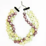 Collar de tres hilos de cuentas redondas de resina en colores lila, verde y amarillo con detalles brillantes.