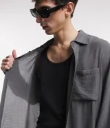 Camisa gris de viscosa con textura, cuello solapa, abotonado delantero y mangas largas.
