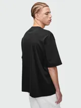 Remera de algodón color negro, de corte holgado y manga corta, con pequeño logo bordado en el centro del pecho.