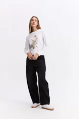 Remera de manga larga color gris oscuro, con cuello redondo y estampa gráfica frontal en tonos blancos y celestes con motivos florales y texto.