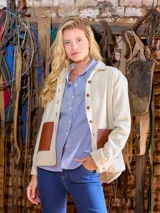 Sobrecamisa de paño color crudo, con cierre frontal de botones, cuello camisero y bolsillos frontales con detalles en cuero marrón.