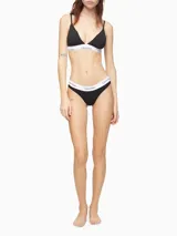 Brasier tipo triángulo con copas forradas y relleno, confeccionado en tejido de algodón modal. Presenta tirantes finos ajustables y una banda elástica inferior distintiva con el logo de Calvin Klein.