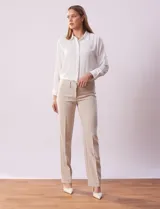 Pantalón de vestir color beige, de corte recto, con bolsillos laterales y traseros. Se ajusta a la cintura con broches internos y cierre.