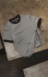 Remera de manga corta con diseño rayado en blanco y negro, con cuello redondo y ribetes negros en cuello y puños.