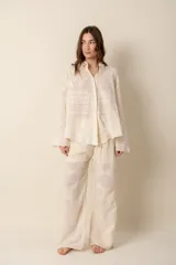 Pantalón ancho color crema con bordados florales, 100% algodón, cintura con elástico y detalle en crochet en la cintura.