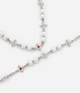 Kit de collar y pulsera metálicos con perlas sintéticas blancas y dijes en forma de cruz decorados con cristales de colores.