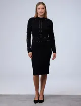 Vestido midi tejido de punto color negro, con cuello alto y mangas largas. Apliques de perlas doradas en el frente y la espalda.