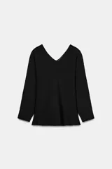 Jersey de punto color negro con escote en V pronunciado en la parte delantera y trasera, manga larga y silueta ligeramente acampanada en la cintura.
