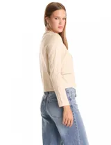 Cardigan corto de punto en color azul marino con textura de rombos en relieve. Presenta un diseño abierto con ribetes decorativos que incluyen detalles de cadena en el cuello, la abertura frontal y los bolsillos simulados.