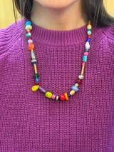 Collar largo confeccionado con cuentas multicolor de diversos materiales, formas y tamaños, incluyendo cristales checos, piedras naturales, acrílico y cerámica. Cuenta con cierre de cadena de acero quirúrgico y ganchito regulable.