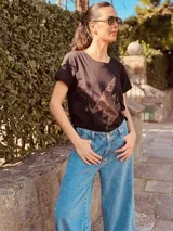 Remera negra de algodón con spandex, cuello redondo y estampado de rayo en gamuza color marrón.