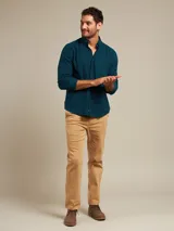 Camisa celeste a cuadros con cuello abotonado, manga larga y bolsillo en el pecho.