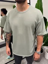 Remera verde claro de punto con cuello redondo y corte holgado.