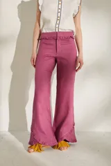 Pantalón morado de corte acampanado con volados decorativos en la cintura y en el ruedo.