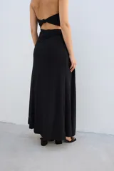 Falda larga de tejido brillante color azul con detalle de nudo en la cintura.