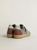 Championes Golden Goose modelo Ball Star, confeccionados en cuero color gris, marrón y beige, con estrella dorada en el lateral, detalles en rojo en el talón y suela de goma color caramelo.
