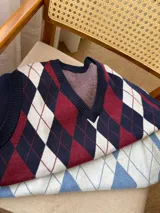 Chaleco de tejido de punto con diseño de rombos en colores azul marino, bordó y blanco. Presenta escote en V y terminaciones acanaladas en cuello, sisas y ruedo.