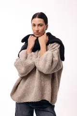 Sweater de punto de textura liviana con escote amplio y mangas largas levemente abullonadas. Presenta un calce relajado y holgado.