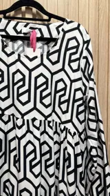 Vestido midi de algodón con estampado geométrico en blanco y negro, corte amplio y mangas largas.