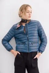 Campera puffer corta a la cintura, de corte holgado, confeccionada en nylon con relleno de plumas. Presenta cuello redondo, cierre frontal y bolsillos laterales con cierre.