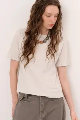 Remera de manga corta y cuello redondo color crudo, corte clásico y holgado.
