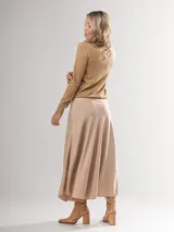 Falda midi color beige con lunares blancos, de corte evasé y cintura elastizada.