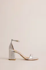 Sandalia de tacón cuadrado medio, con diseño minimalista de una tira delantera y pulsera ajustable al tobillo con hebilla metálica.