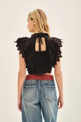 Camisa corta de voile de algodón negro, con escote redondo y mangas con volados decorados con puntilla de algodón bordada.