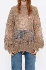 Sweater de mohair color beige, de corte oversize, escote redondo y manga larga.