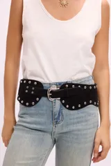 Cinto ancho de gamuza color tostado con diseño curvo, decorado con tachas metálicas plateadas y hebilla central metálica.