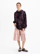 Buzo tipo hoodie oversize de tela de punto frizada, con estampa full print en tonos negro y bordó. Presenta capucha con cordones ajustables, puños y cintura con terminaciones en ribb.