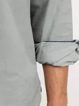 Camisa de micropana celeste para hombre, de corte regular fit y manga larga. Cuenta con cuello abotonado, cierre frontal con botones y detalle de vivo liso en el interior de los puños.