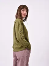 Buzo color verde oliva de corte holgado con cuello redondo y mangas largas con calados.