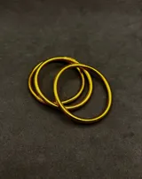Set de pulseras circulares flexibles de estilo oriental, con acabado brillante en tonos dorados y plateados, rellenas de lámina metálica.