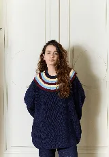 Buzo de punto oversize color azul marino con cuello babero amplio y franjas de colores en tono amarillo, celeste y bordó.