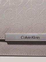 Billetera Calvin Klein de plegado triple, color gris con monograma de la marca en toda la superficie y barra plateada con el logo grabado.
