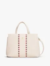 Cartera tipo satchel de Tommy Hilfiger en color beige, confeccionada en poliuretano con textura granulada. Presenta doble asa superior, correa ajustable extraíble, logo TH metalizado en el frente y dos franjas verticales decorativas con detalles entrelazados en rojo y negro.