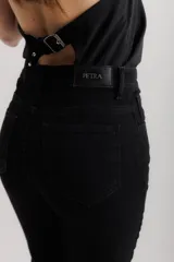 Jean elastizado azul oscuro con diseño de volados en la parte baja de la pierna, ruedo descosido con juego de largos (más largo atrás que adelante).