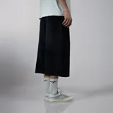 Bermuda de jean negro con corte ancho y largo a la rodilla.