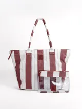 Bolso tipo tote rayado en color blanco y bordó, con asas largas de hombro y cierre superior. Incluye un neceser transparente a juego con detalles rayados.