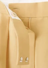 Pantalón recto de tiro medio color beige, confeccionado en mezcla de lino y viscosa. Cuenta con detalle de pinzas, bolsillos laterales y cierre frontal oculto con cremallera, botón y ganchos con tapeta.