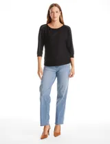 Blusa de tejido acanalado con cuello redondo y mangas tres cuartos. Presenta detalle de tachas metálicas a lo largo de los hombros y mangas, con puños elastizados.