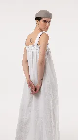 Vestido largo de lino color marrón, de silueta amplia y caída liviana, con escote cuadrado, frunces elastizados en el pecho y breteles anchos con detalles de volados.